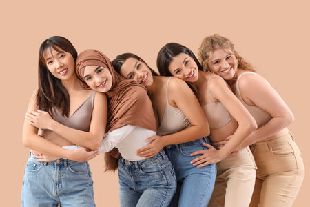 Group of young women hugging on beige backgroundの写真素材