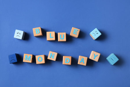Wooden cubes with text BLUE MONDAY and drawn sad facesの写真素材