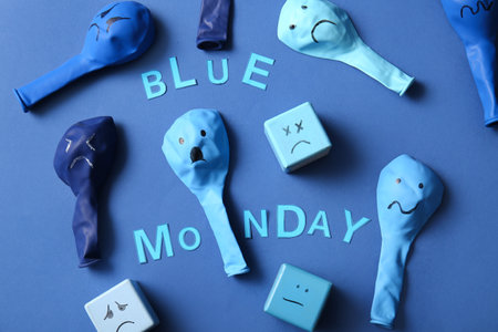 Cubes and balloons with drawn sad faces and text BLUE MONDAYの写真素材