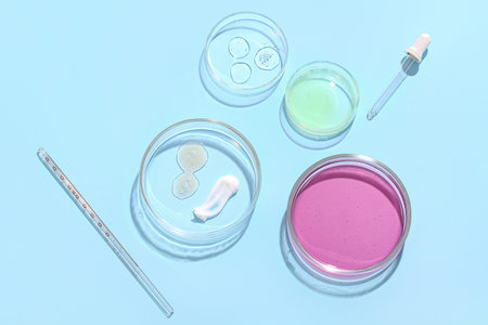 Petri dishes with samples and pipette on blue background