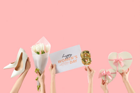 Female hands holding postcard with flowers, gift boxes and shoes on pink background. Shopping for International Women's Dayの写真素材