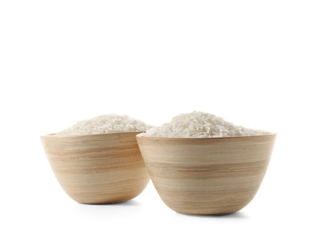 Wooden bowls with raw rice isolated on white backgroundの写真素材