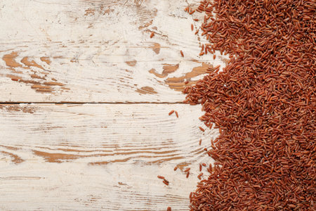 Raw brown rice on beige wooden backgroundの写真素材