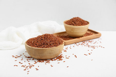 Tray with bowls of raw brown rice on white backgroundの写真素材