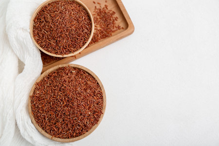 Tray with bowls of raw brown rice on white backgroundの写真素材