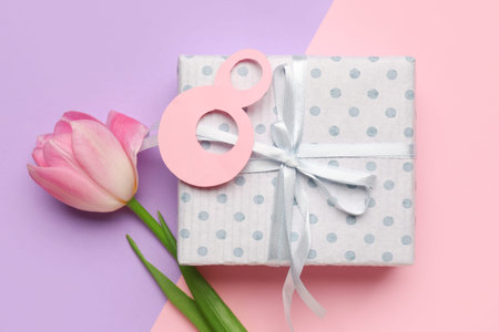 Figure 8 made of paper with gift box and beautiful tulip on colorful background. International...