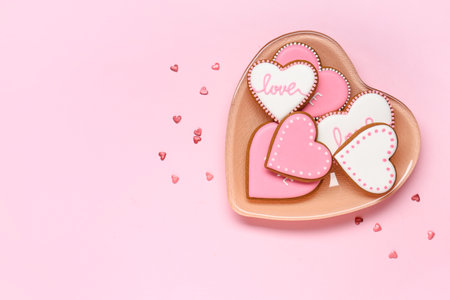 Plate with heart shaped cookies on pink background. Valentine's day celebrationの写真素材