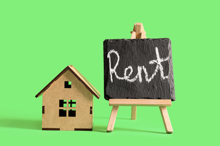Toy house with the word RENT on green backgroundの写真素材