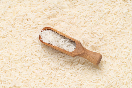 Closeup view of wooden scoop and raw rice as background, closeupの写真素材