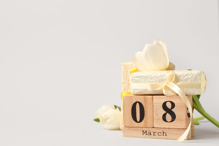 Cube calendar, gift boxes and white flowers for International Women's Day celebration on white...