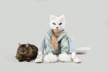 Quadrober girl with cute cat sitting on light background