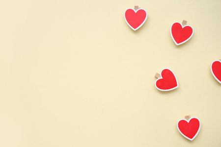 Heart shaped decorations with clothespins on beige background. Valentine's Day celebrationの写真素材