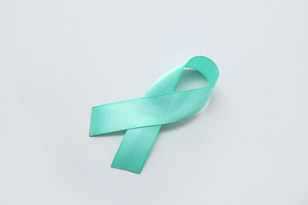 Turquoise ribbon on white background. Cervical Health Awareness Month