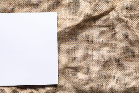 Blank card on crumpled burlap fabric