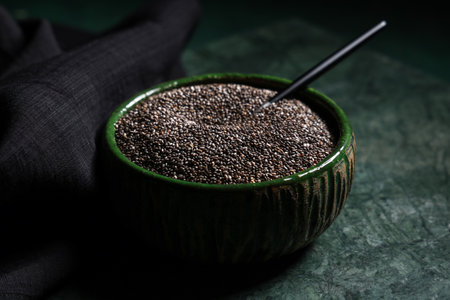 Bowl with chia seeds on green backgroundの写真素材