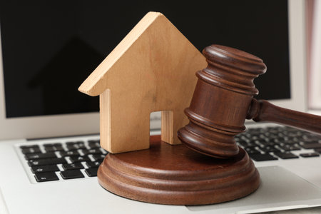 Auction gavel with house figure on laptop, closeupの写真素材
