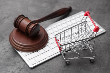 Auction gavel with shopping cart and computer keyboard on dark background, closeupの写真素材