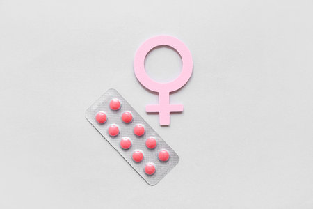 Paper symbol of woman and hormonal pills on light backgroundの写真素材