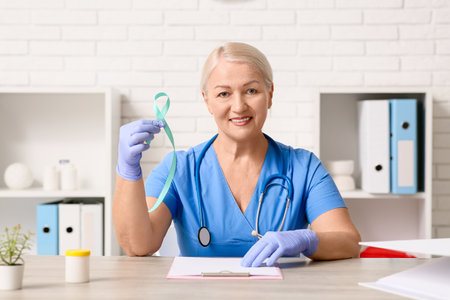 Mature female doctor with teal ribbon in clinic. Cervical Health Awareness Monthの写真素材