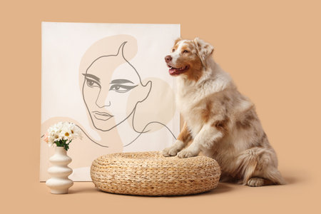 Cute Australian Shepherd dog with painting and flowers against beige backgroundの写真素材