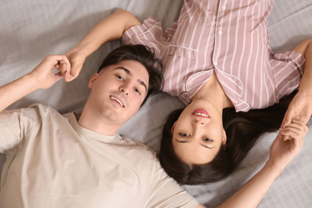 Young couple lying together in bed, top viewの写真素材