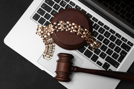 Auction gavel with golden bracelet and laptop on dark backgroundの写真素材