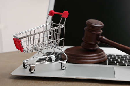 Shopping cart with auction gavel and laptop on table, closeupの写真素材