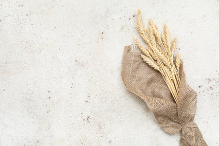 Burlap cloth with wheat ears on light backgroundの写真素材