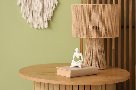 Stylish coffee table with lamp, book and decor near light green wall, closeupの写真素材