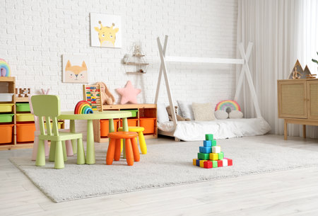 Interior of children's bedroom with bed, table and toysの写真素材