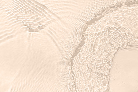 Texture of clean water with ripples on beige background