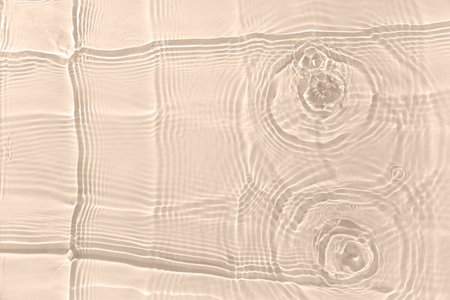 Texture of clean water with splashes on beige backgroundの写真素材