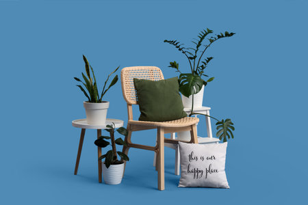 Wooden chair with cushion and houseplants on blue backgroundの写真素材
