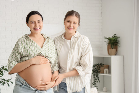 Young doula with pregnant woman smiling at home
