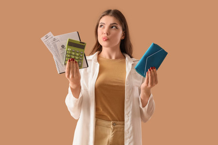 Thoughtful young woman with purse, calculator and receipts from food market on beige background