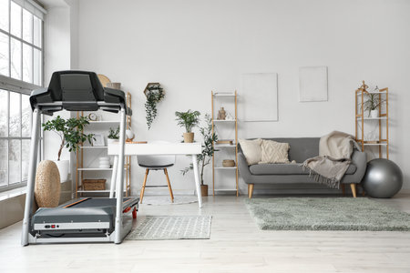 Interior of living room with treadmill, sofa and shelf unitsの写真素材