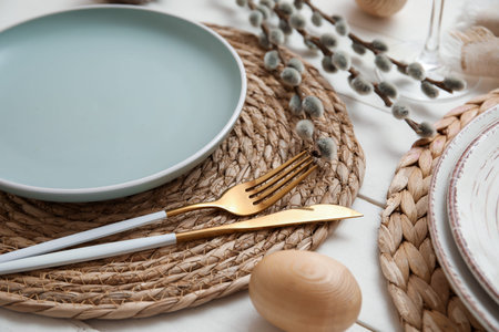 Beautiful table setting with Easter egg and pussy willow branches on white wooden background,...