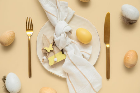 Beautiful table setting with Easter eggs and wooden bunny on beige background