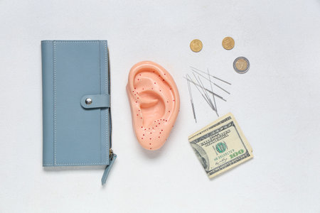 Acupuncture supplies with wallet and money on white background