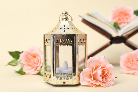 Fanoos with Koran and beautiful flowers on beige background. Ramadan celebration