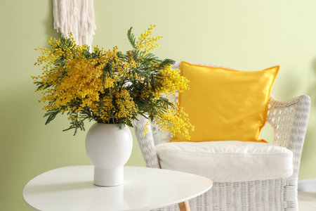 Vase with mimosa flowers on table in living roomの写真素材