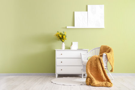 Interior of room with armchair, commode and mimosa flowers in vaseの写真素材