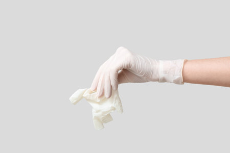 Female hand with medical glove on gray backgroundの写真素材