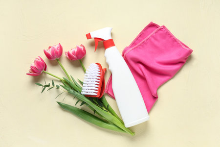 Cleaning supplies with spring flowers on beige backgroundの写真素材