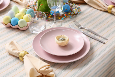 Festive Easter table setting with colorful eggs. Closeup