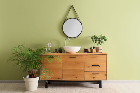 Interior of bathroom with sink, cosmetic products and mirror