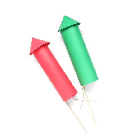 Green and red firework rockets on white background