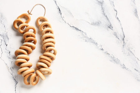 String of tasty bagels on marble background