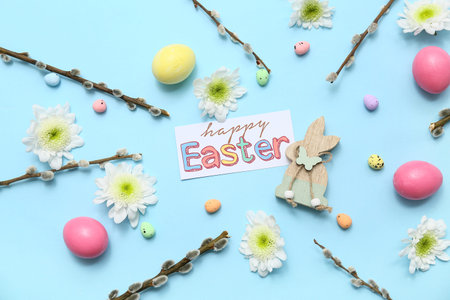 Easter postcard with eggs, flowers and willow branches on blue background