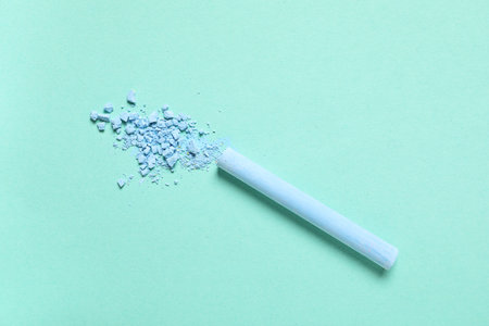 Blue chalk with crushed pigment on turquoise background
